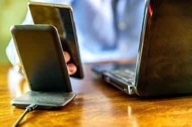 Adam akıllı telefonu kablosuz şarj cihazıyla şarj ediyor.