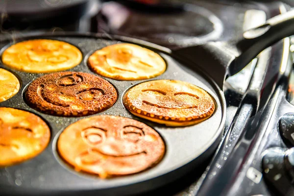 Сковородка с улыбкой блины лицо приготовления пищи на плита на кухне — стоковое фото