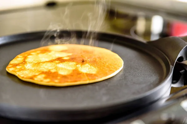 Pancake frying pan with crepe pancake cooking on cooker in kitchen — Stock Photo, Image