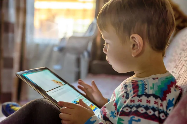 Peuter jongen kijken spelen met digitale tablet op bank thuis — Stockfoto