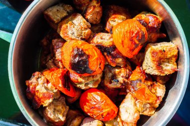 Tencere güvecinde ızgara et ve domates.