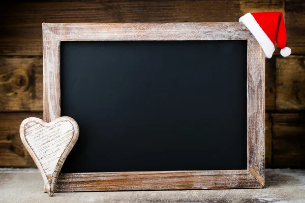 Lavagna natalizia con decorazione. Cappello Babbo Natale, stelle, legno — Foto Stock