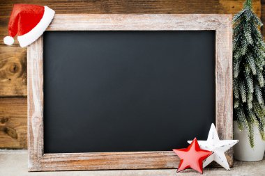 Noel dekorasyonu ile kara tahta. Noel Baba şapkası, yıldız, tahta 