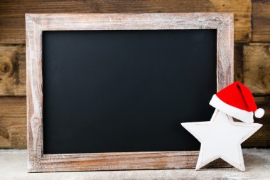 Noel dekorasyonu ile kara tahta. Noel Baba şapkası, yıldız, tahta 