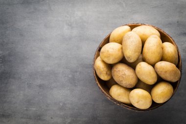 Kase, gri arka plan üzerinde yeni patates.