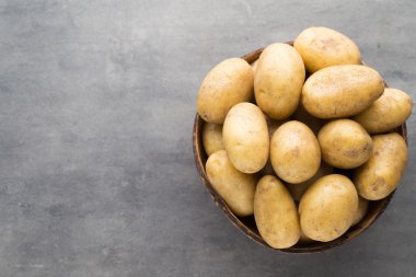 Kase, gri arka plan üzerinde yeni patates.