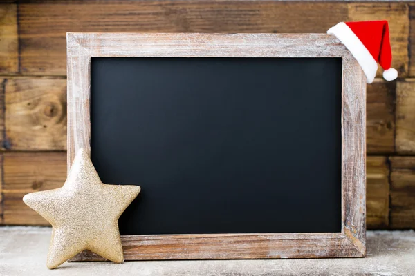 Lavagna natalizia con decorazione. Cappello Babbo Natale, stelle, legno — Foto Stock