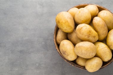 Kase, gri arka plan üzerinde yeni patates.
