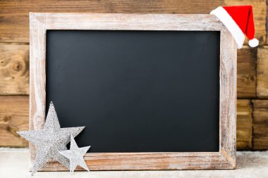 Noel dekorasyonu ile kara tahta. Noel Baba şapkası, yıldız, tahta 