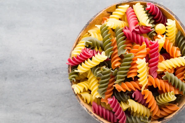 Pasta maccheroni in una ciotola di legno su fondo grigio . — Foto Stock