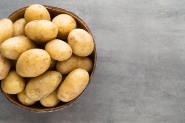 Kase, gri arka plan üzerinde yeni patates.