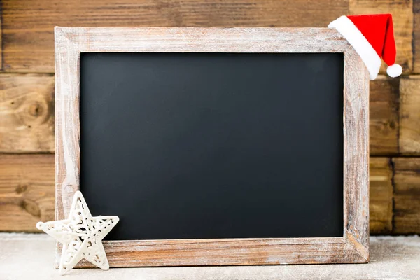 Vánoční tabule s výzdobou. Santa čepice, hvězdy, dřevěné — Stock fotografie