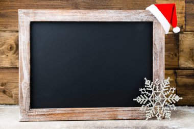 Noel dekorasyonu ile kara tahta. Noel Baba şapkası, yıldız, tahta 