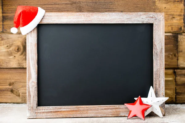 Pizarra de Navidad con decoración. Sombrero de Santa, estrellas, Madera — Foto de Stock