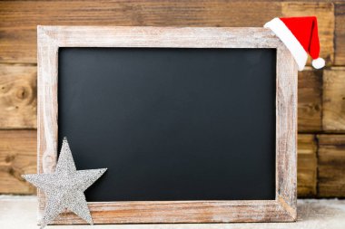 Noel dekorasyonu ile kara tahta. Noel Baba şapkası, yıldız, tahta 