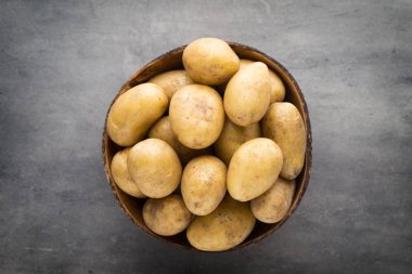 Kase, gri arka plan üzerinde yeni patates.