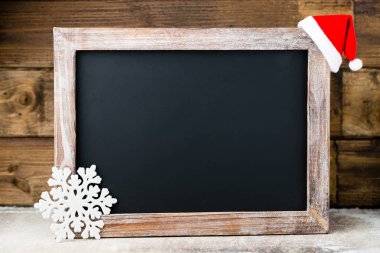 Noel dekorasyonu ile kara tahta. Noel Baba şapkası, yıldız, tahta 