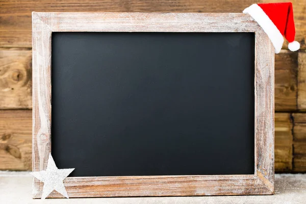 Christmas chalkboard with decoration. Santa hat, stars,  Wooden — Stock Photo, Image