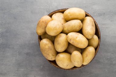 Kase, gri arka plan üzerinde yeni patates.