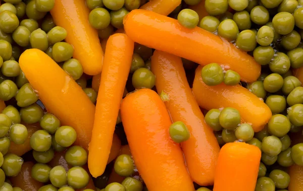 Zanahorias con guisantes verdes fondo vegetal. — Foto de Stock