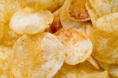 Patates cipslerini ahşap arka planda kapat.