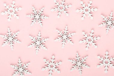 Noel arkaplanı. Pembe arka planda beyaz kar dekorasyonları.