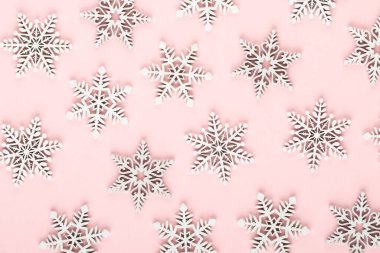 Noel arkaplanı. Pembe arka planda beyaz kar dekorasyonları.