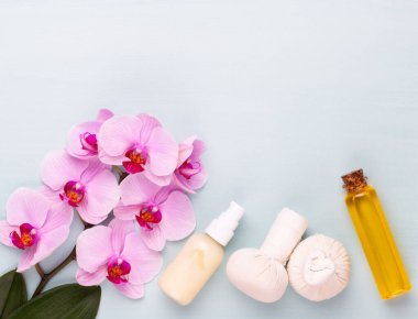 Spa aromaterapi arka planı, basit orkide çiçekleriyle süslenmiş çeşitli güzellik ürünleri..