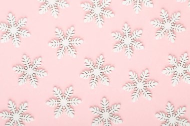 Noel arkaplanı. Pembe arka planda beyaz kar dekorasyonları.