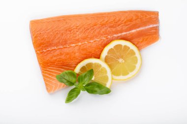 Limonlu kırmızı balık somonu dilimi, beyaz arka planda yalıtılmış fesleğen. Üst Manzara. Düz yatıyordu