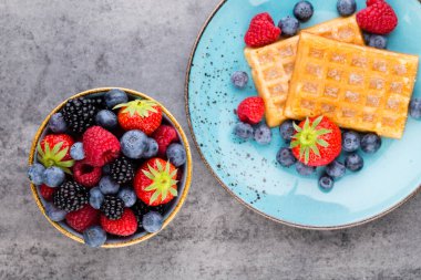 Ahşap arka planda bir tabakta taze meyve salatası. Düz konum, üst görünüm, kopyalama alanı.