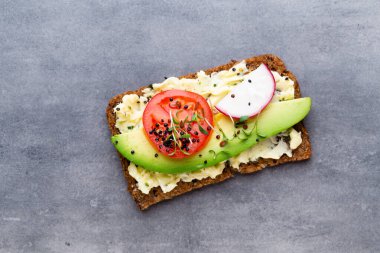 Krem peynirli, sebzeli ve salamlı mini sandviçler. Salatalıklı sandviçler, turp, domates, gri arka planda salam, üst manzara. Düz yatıyordu.