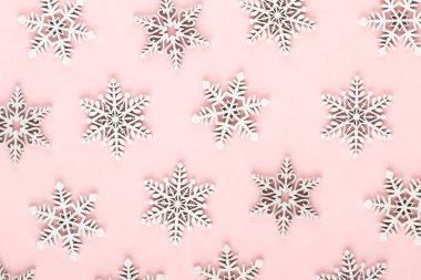 Noel arkaplanı. Pembe arka planda beyaz kar dekorasyonları.