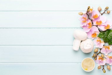Spa aromaterapi arka planı, basit orkide çiçekleriyle süslenmiş çeşitli güzellik ürünleri..