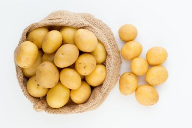 Ahşap arka planda taze çiğ patates çuvalı.