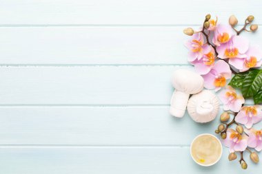 Spa aromaterapi arka planı, basit orkide çiçekleriyle süslenmiş çeşitli güzellik ürünleri..