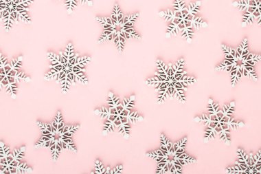 Noel arkaplanı. Pembe arka planda beyaz kar dekorasyonları.