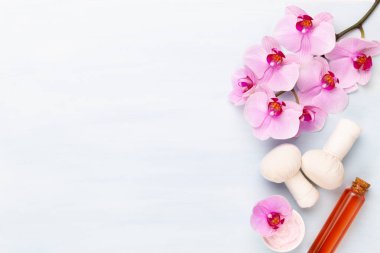 Spa aromaterapi arka planı, basit orkide çiçekleriyle süslenmiş çeşitli güzellik ürünleri..