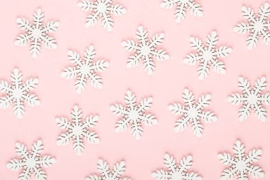 Noel arkaplanı. Pembe arka planda beyaz kar dekorasyonları.