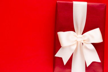 Kırmızı masa üstünde kurdeleli düzenlenmiş noel hediye kutularının üst görünümü.