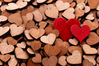 Tahta kalplerin arka planı, kırmızı kalp. Bir sürü dekoratif tahta kalp şenlikli bir arka plan olarak kullanılıyor..