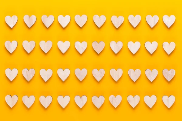Małe Drewniane Serduszka Żółtym Tle Kreatywny Pomysł Walentynki Kartka Życzeniami — Zdjęcie stockowe