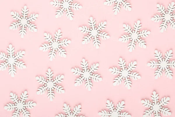 Noel arkaplanı. Pembe arka planda beyaz kar dekorasyonları.