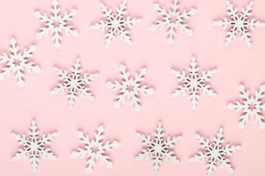 Noel arkaplanı. Pembe arka planda beyaz kar dekorasyonları.