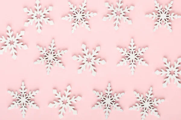 Noel arkaplanı. Pembe arka planda beyaz kar dekorasyonları.