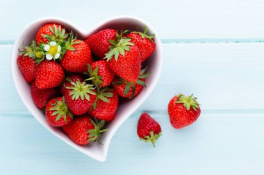Çilekli kalp. Beyaz ahşap masadaki taze çilekler. Üst görünüm, alanı kopyala. 