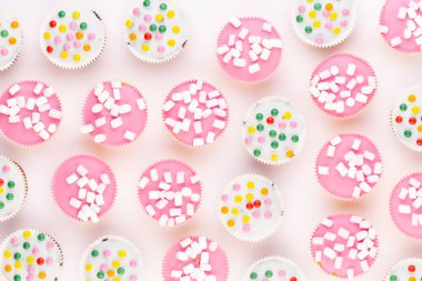 Beyaz arka planda çok renkli, güzel dekore edilmiş muffinler..