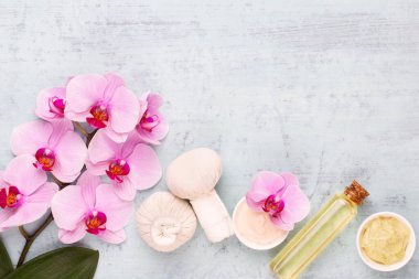 Spa aromaterapi arka planı, basit orkide çiçekleriyle süslenmiş çeşitli güzellik ürünleri..