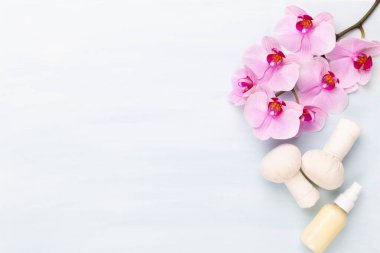Spa aromaterapi arka planı, basit orkide çiçekleriyle süslenmiş çeşitli güzellik ürünleri..