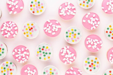 Beyaz arka planda çok renkli, güzel dekore edilmiş muffinler..